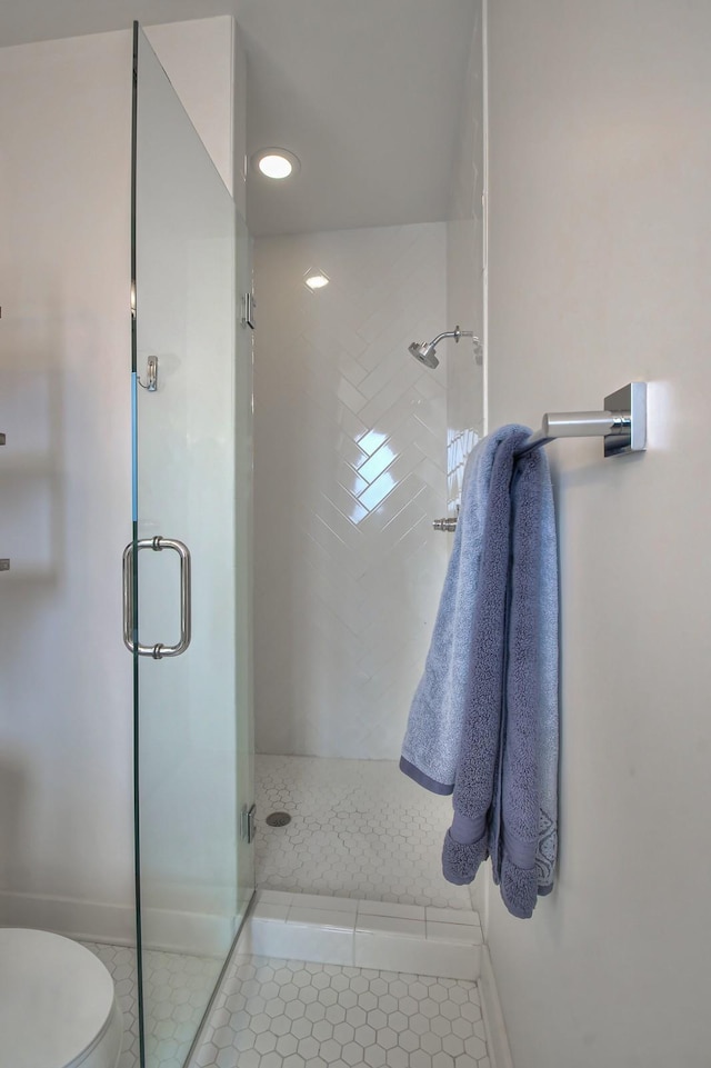 full bathroom with a shower stall, tile patterned flooring, toilet, and baseboards