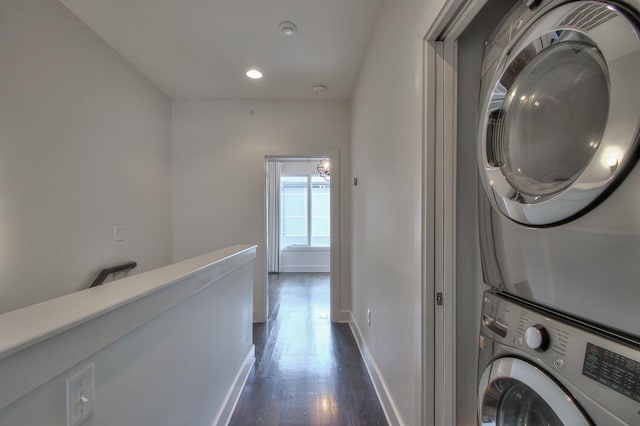 washroom featuring stacked washer / dryer, dark wood finished floors, baseboards, and recessed lighting