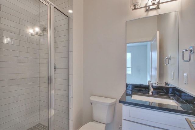 bathroom featuring toilet, a stall shower, and vanity