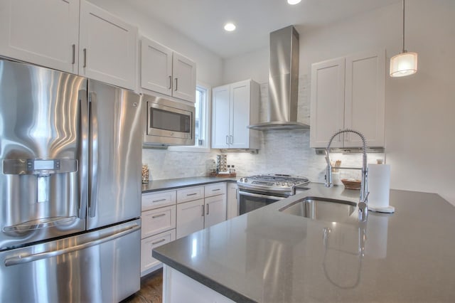 kitchen with stainless steel appliances, wall chimney range hood, a sink, dark countertops, and decorative backsplash