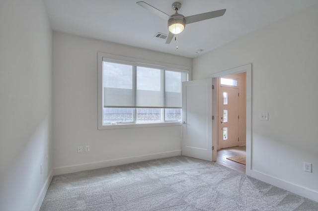 carpeted empty room with baseboards and ceiling fan