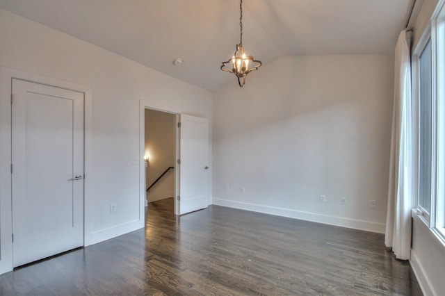 unfurnished bedroom with lofted ceiling, dark wood-style floors, a chandelier, and baseboards