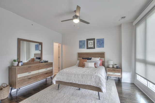 bedroom with dark wood-type flooring, a ceiling fan, and baseboards