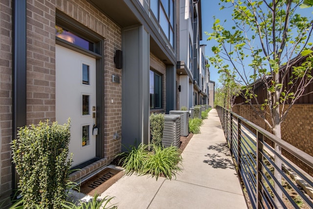 entrance to property featuring brick siding and cooling unit