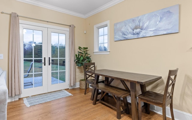 doorway with light wood finished floors, french doors, baseboards, and crown molding