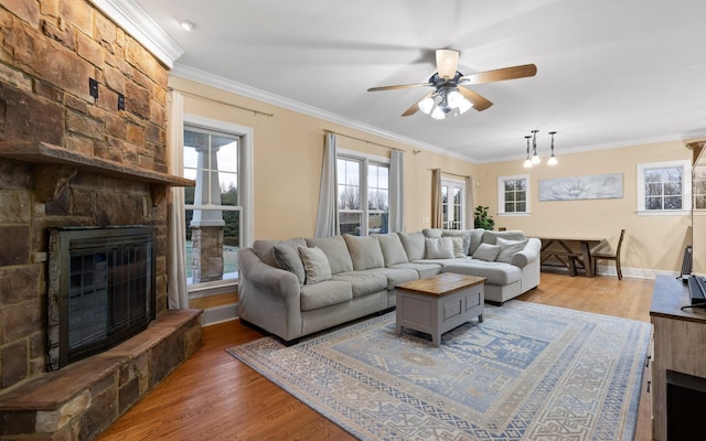 living area with crown molding, a ceiling fan, and wood finished floors
