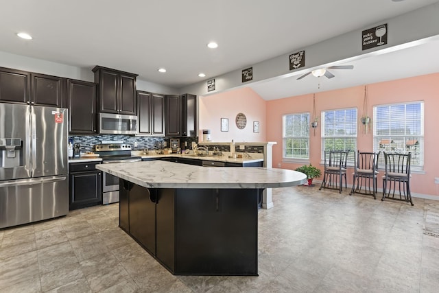 kitchen with light countertops, appliances with stainless steel finishes, tasteful backsplash, and ceiling fan