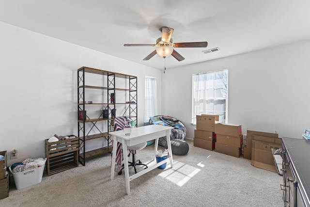 carpeted office space featuring a ceiling fan and visible vents