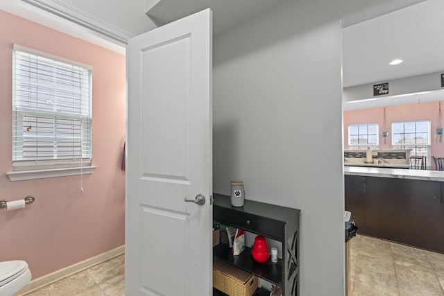 bathroom featuring recessed lighting, baseboards, toilet, and stone finish flooring
