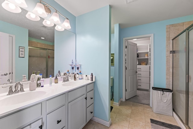 full bathroom with double vanity, a sink, a notable chandelier, and a shower stall
