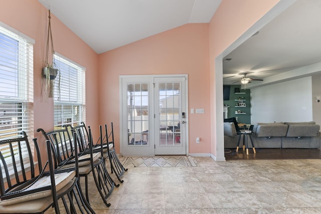 doorway with baseboards, a ceiling fan, and vaulted ceiling