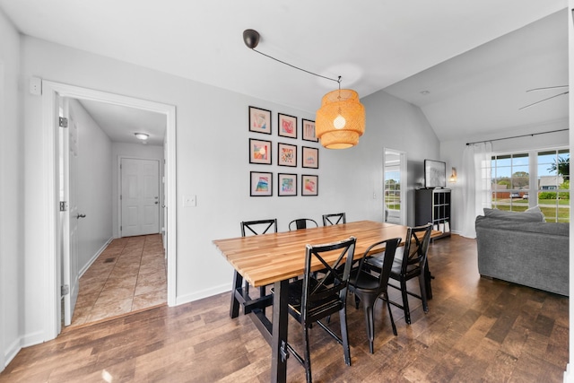 dining area featuring baseboards, wood finished floors, and lofted ceiling