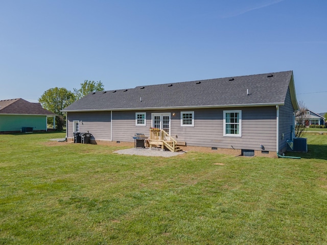 rear view of property with roof with shingles, crawl space, central AC, and a lawn