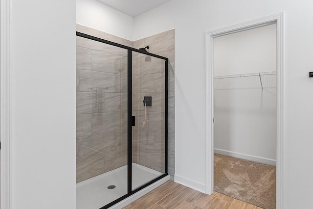 8524 Turnbull Dr, Pleasant View, TN 37146 - full bath with a stall shower, a walk in closet, wood finished floors, and baseboards