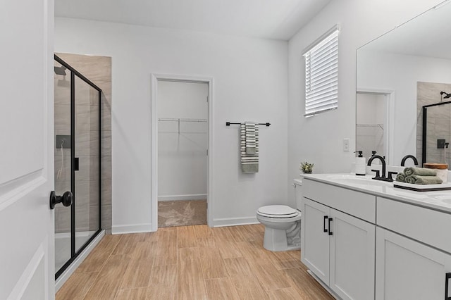 8524 Turnbull Dr, Pleasant View, TN 37146 - bathroom with a spacious closet, a stall shower, double vanity, toilet, and wood finished floors