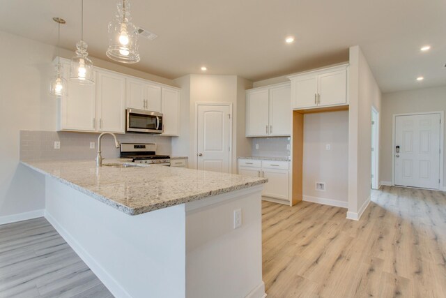 8583 Turnbull Dr, Pleasant View, TN 37146 - kitchen with visible vents, appliances with stainless steel finishes, a peninsula, and light wood finished floors