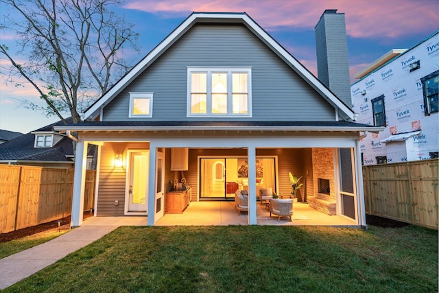 2109 10th Ave S, Nashville, TN 37204 - back of house at dusk featuring a patio, fence, and a lawn