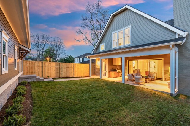 2109 10th Ave S, Nashville, TN 37204 - back of property at dusk with a patio, an outdoor living space, a yard, and fence