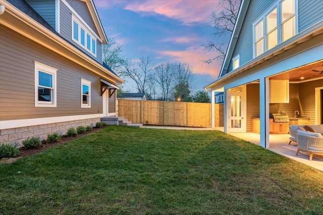 2109 10th Ave S, Nashville, TN 37204 - yard at dusk with exterior kitchen, a patio area, and fence