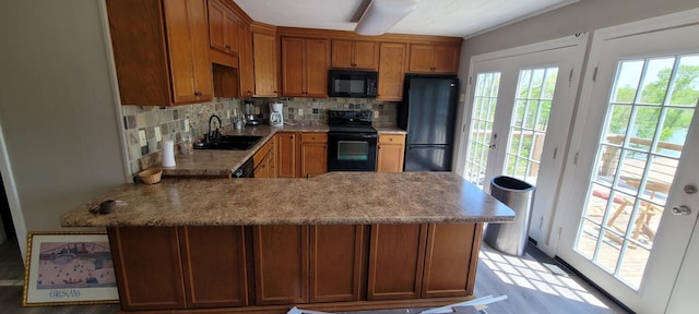 1124 Woodlawn Shores Rd, Sugar Tree, TN 38380 - kitchen with a peninsula, light countertops, black appliances, decorative backsplash, and a sink