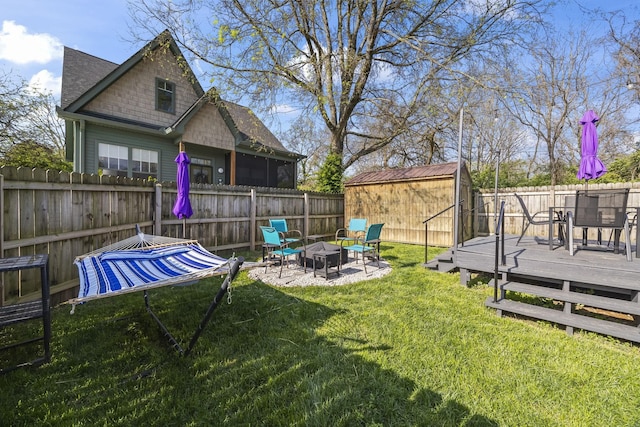 1204A Keller Ave, Nashville, TN 37216 - view of yard featuring a fire pit, a deck, a shed, a fenced backyard, and an outbuilding