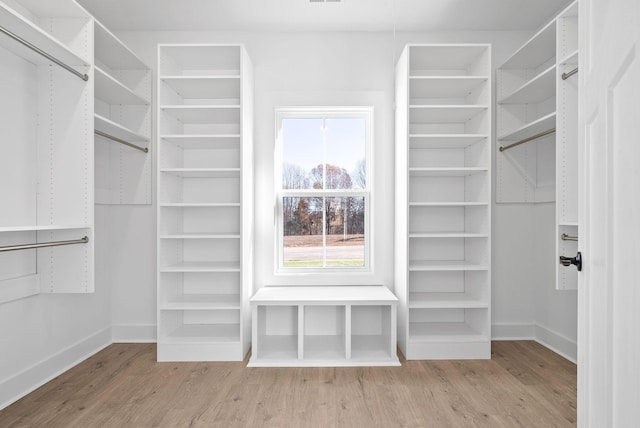 walk in closet with wood finished floors