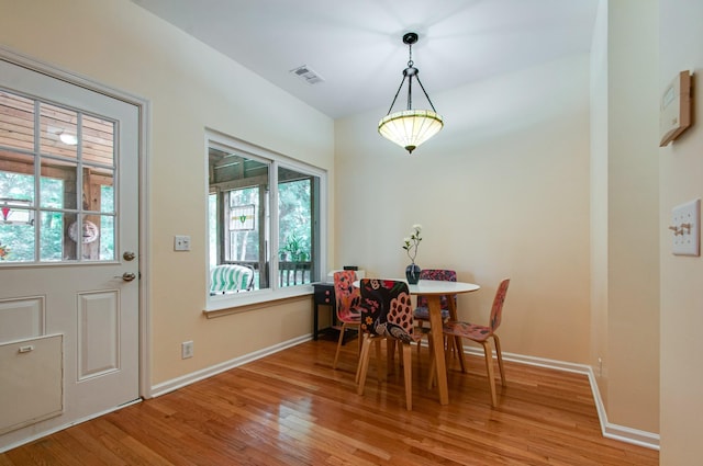 dining space featuring wood finished floors, baseboards, visible vents, and plenty of natural light