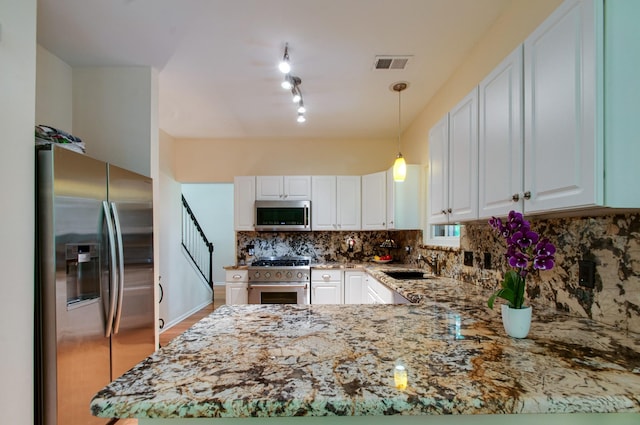 kitchen with light stone counters, white cabinets, visible vents, appliances with stainless steel finishes, and a sink