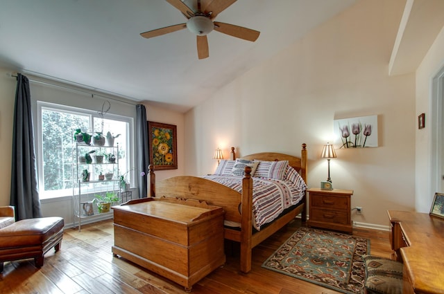 bedroom with wood finished floors, high vaulted ceiling, baseboards, and a ceiling fan