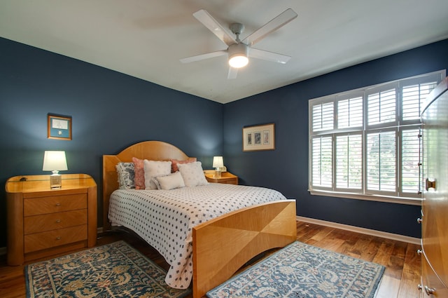 bedroom featuring ceiling fan, baseboards, and wood finished floors