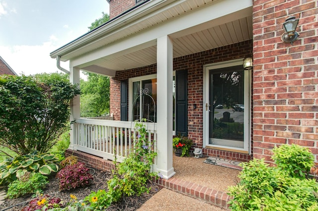 property entrance featuring covered porch and brick siding