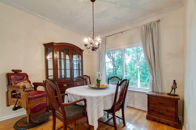dining room featuring light wood-type flooring, an inviting chandelier, baseboards, and ornamental molding