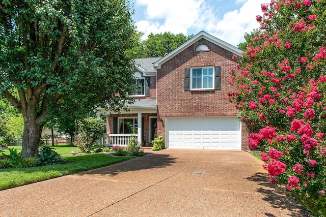 traditional-style home with brick siding, an attached garage, driveway, and a porch
