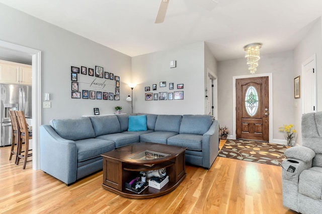134 Joe Blanton Rd, Woodbury, TN 37190 - living room with baseboards, light wood-style floors, and ceiling fan with notable chandelier
