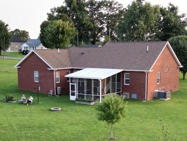 134 Joe Blanton Rd, Woodbury, TN 37190 - back of property with a sunroom, central air condition unit, a lawn, an outdoor fire pit, and brick siding