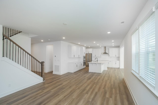 unfurnished living room featuring baseboards, a wealth of natural light, and light wood-style flooring