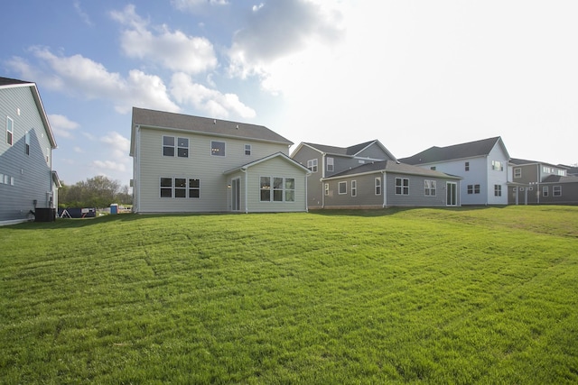 rear view of property featuring a lawn