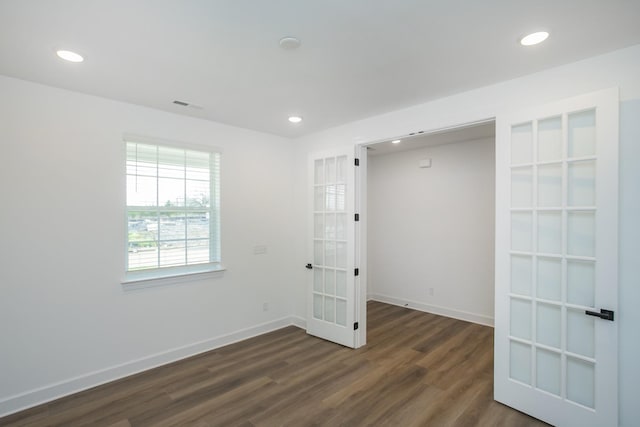 empty room featuring dark wood-style floors, baseboards, french doors, and recessed lighting