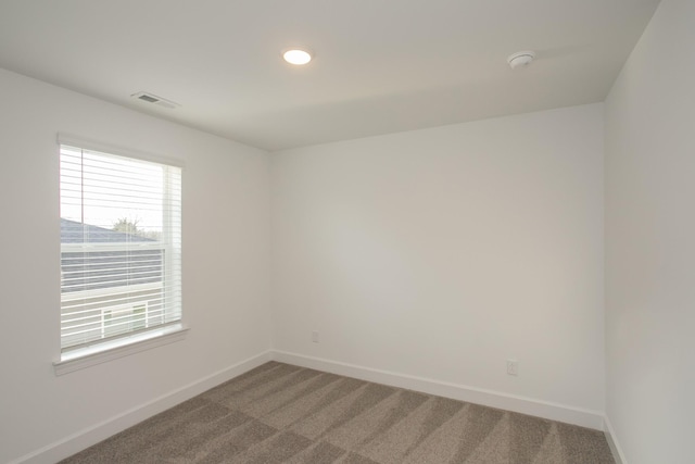 unfurnished room featuring baseboards, visible vents, and plenty of natural light