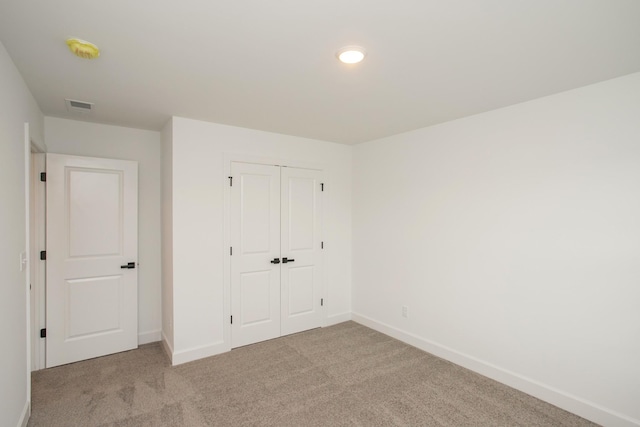 unfurnished bedroom with visible vents, carpet, and baseboards