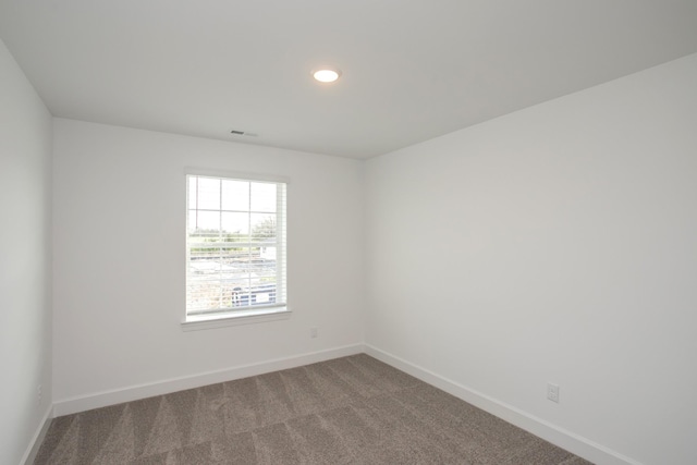 unfurnished room with recessed lighting, visible vents, carpet, and baseboards