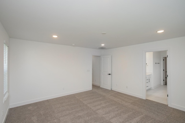 spare room with recessed lighting, light colored carpet, and baseboards