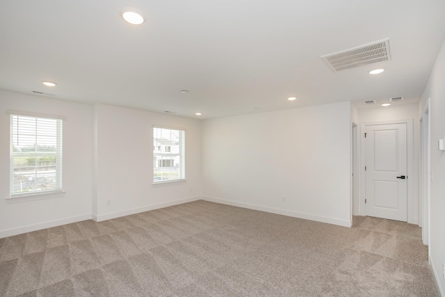 spare room with visible vents, recessed lighting, baseboards, and light carpet