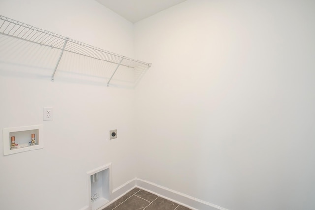 laundry area with hookup for a washing machine, laundry area, dark tile patterned floors, hookup for an electric dryer, and baseboards