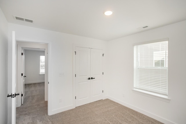 unfurnished bedroom with baseboards, visible vents, and carpet floors