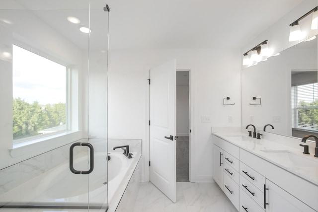 bathroom featuring a bath, marble finish floor, a sink, and double vanity