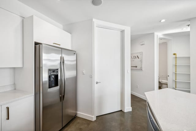 1510 Demonbreun St Unit 511, Nashville, TN 37203 - kitchen with stainless steel fridge, white cabinetry, light countertops, baseboards, and recessed lighting