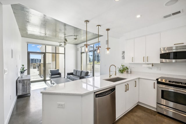 1510 Demonbreun St Unit 511, Nashville, TN 37203 - kitchen with appliances with stainless steel finishes, a sink, concrete flooring, a peninsula, and light countertops