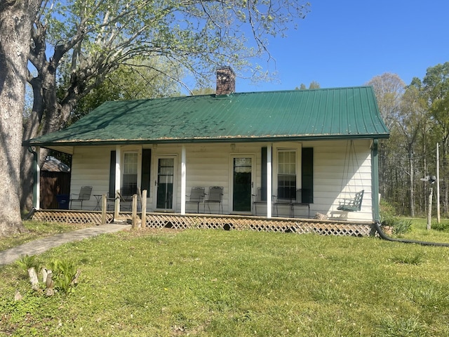 312 Neal St, Huntland, TN 37345 - rear view of house with a yard, metal roof, a chimney, and covered porch