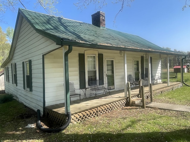 312 Neal St, Huntland, TN 37345 - view of side of property featuring a standing seam roof, metal roof, a chimney, and covered porch